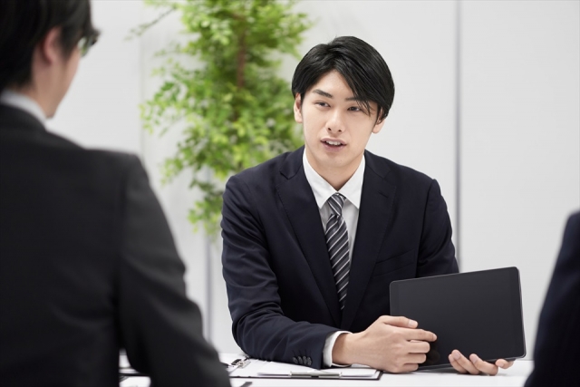 対面で説明する日本人男性ビジネスマン